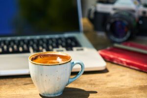 cup of coffee in front of computer